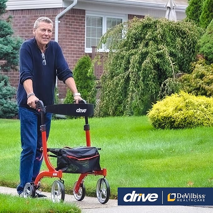 Man using Drive Medical Nitro rollator walker on a sidewalk with lush green grass and shrubs.