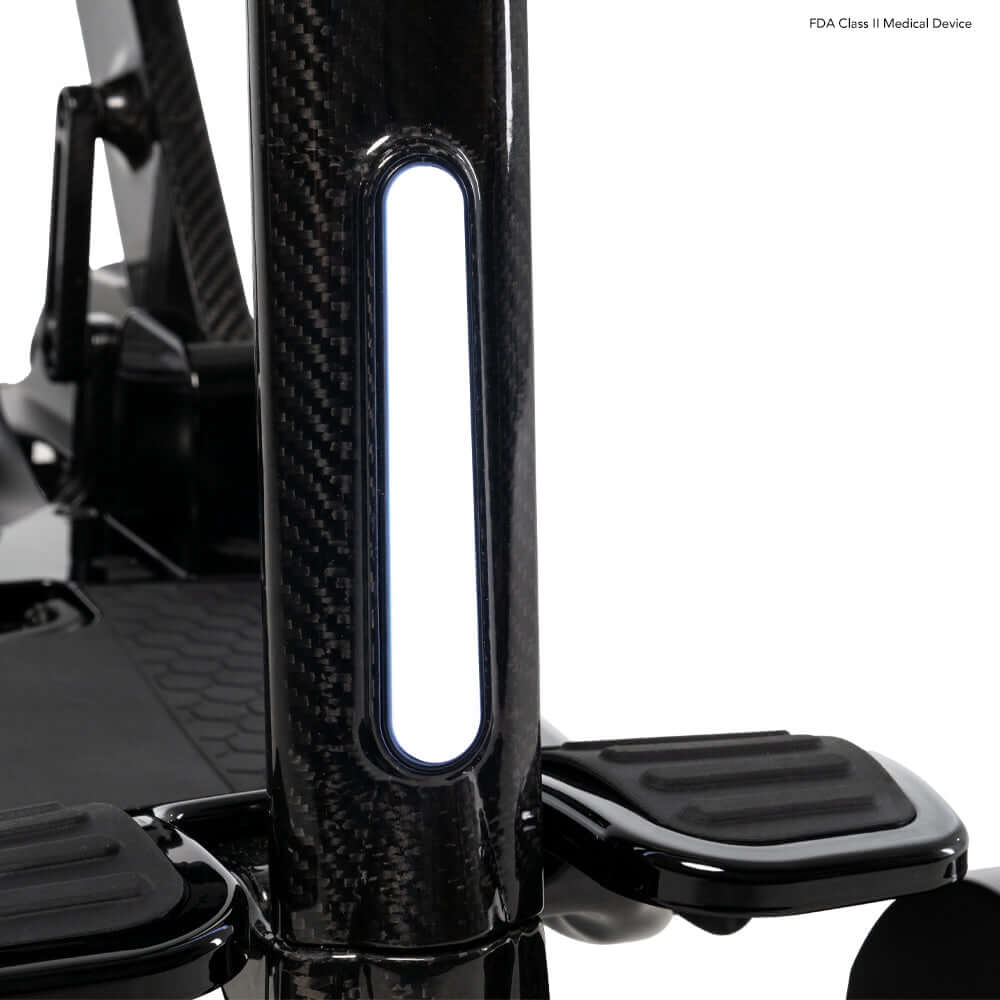 Close-up view of the Go Go® Carbon Folding Mobility Scooter's carbon fiber frame and footrest area.